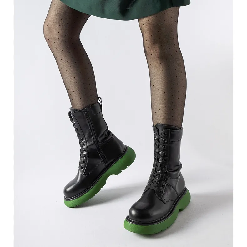 Black insulated boots with a green Beata sole